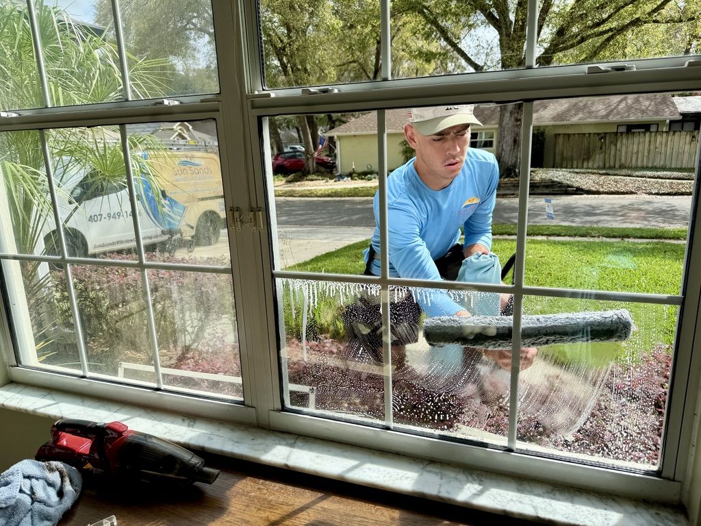 Sun Sands technician cleaning a window in Windermere, FL